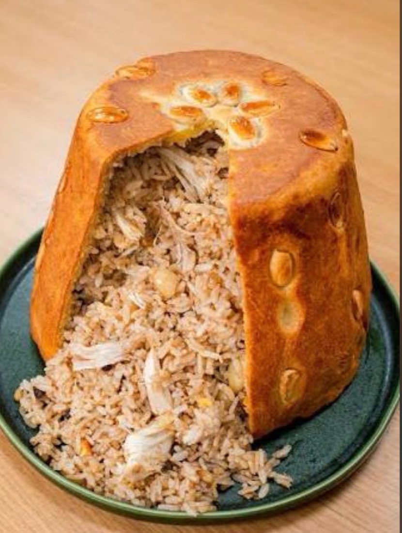 Whole roasted chicken and rice baked inside a golden bread dome